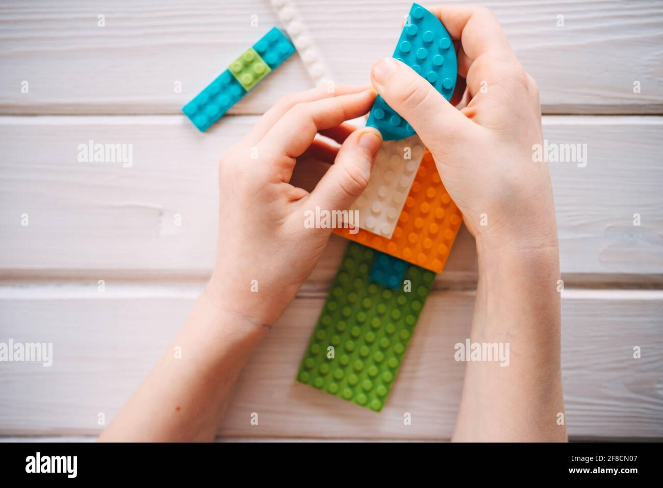 Mädchen sammelt Konstrukteur aus farbigen Blöcken Stockfoto