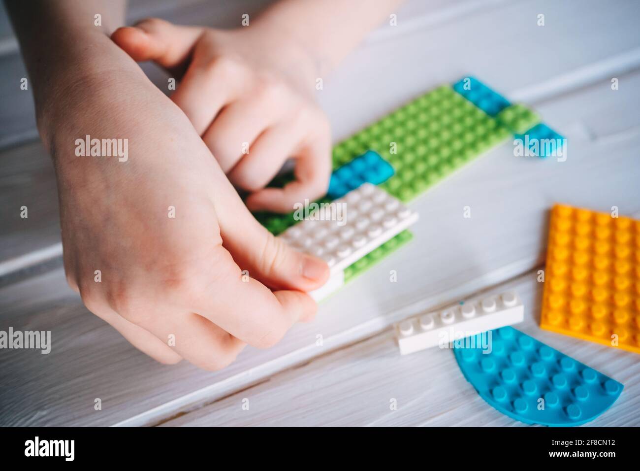 Mädchen sammelt Konstrukteur aus farbigen Blöcken Stockfoto