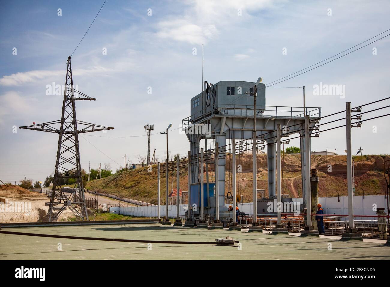 Teil des Wasserkraftwerks und Staudamm am Fluss Shardara. Portalkran rechts, Elektromast links. Blauer Himmel. Stockfoto