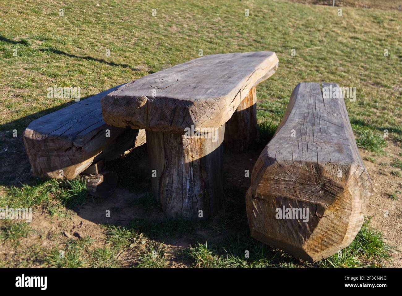 Italienische alpine Landschaft mit Bänken und Tischen aus einem geschnitzten Holzstamm vor einer Hütte Stockfoto