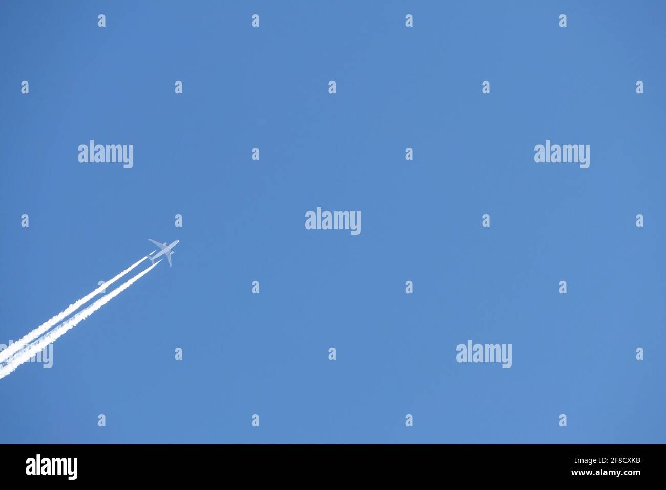 Ein Düsenflugzeug am Himmel. Eine Doppelspur von einem Düsenflugzeug in einem blauen Himmel. Stockfoto