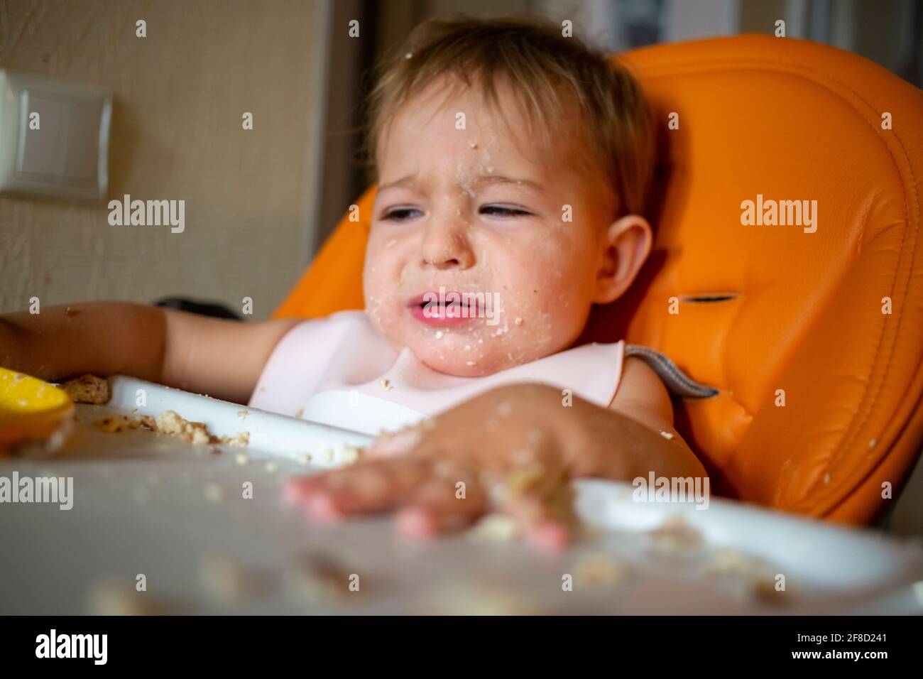 Porträt von niedlichen weinenden Baby Kleinkind sitzen mit Esstisch. Stockfoto