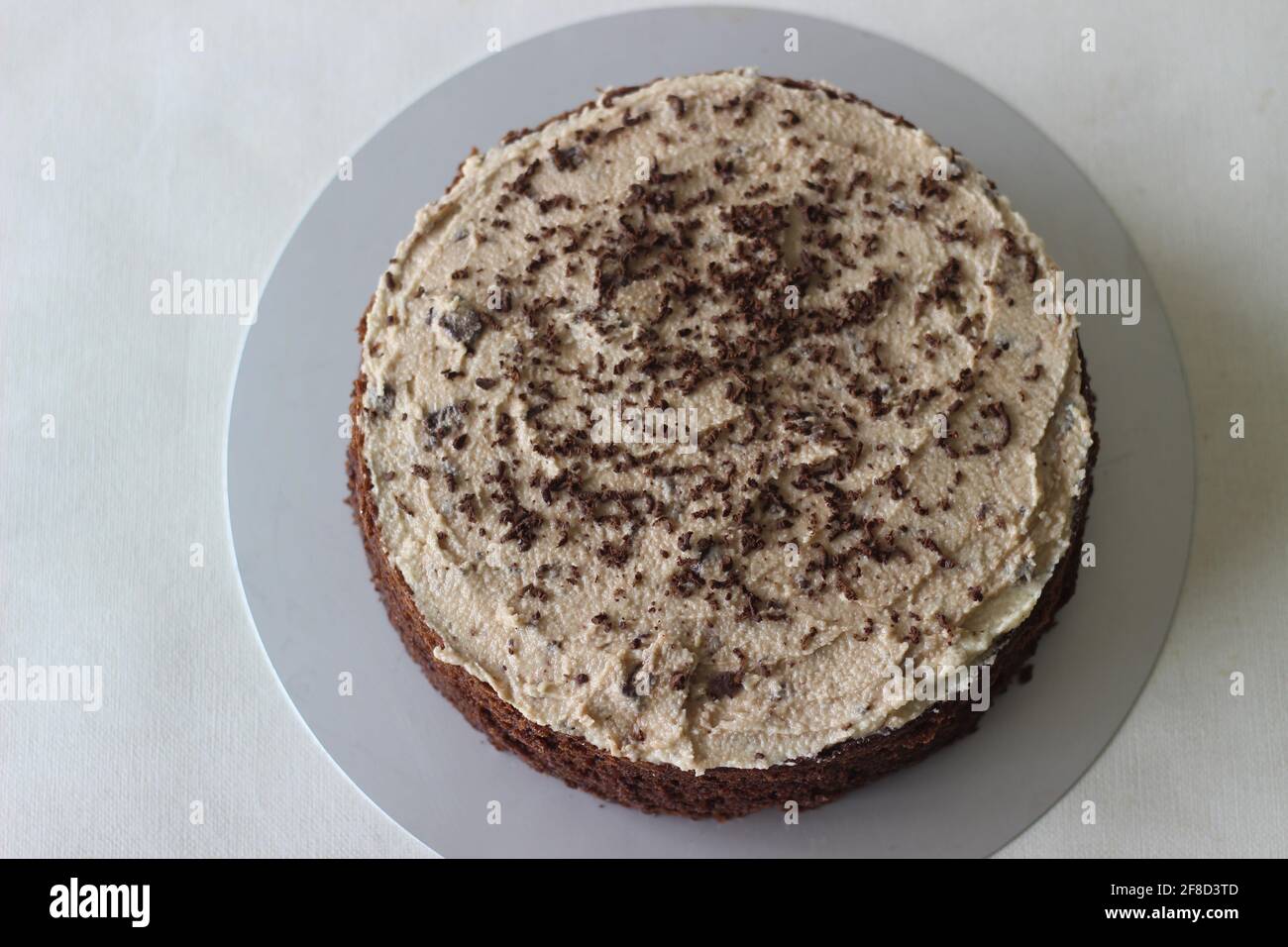 Schokoladenkuchen mit Vanillebutter-Pudereis gemischt mit Schokolade als Belag. Aufgenommen auf weißem Hintergrund. Stockfoto