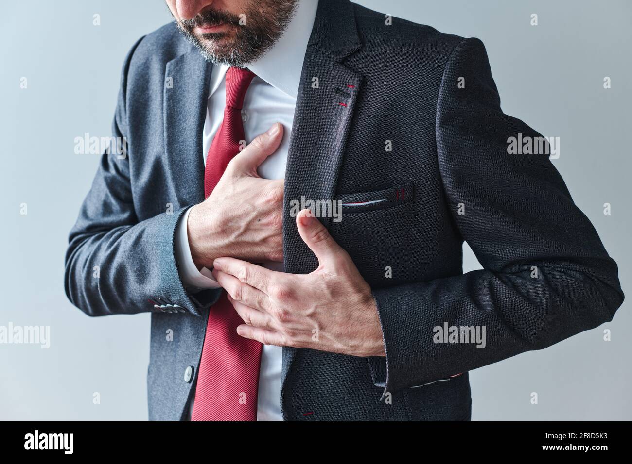 Geschäftsmann mit Herz-Kreislauf-Problemen, erwachsener männlicher Unternehmer mit Herzinfarkt, Druck auf die Brust mit der Hand Stockfoto