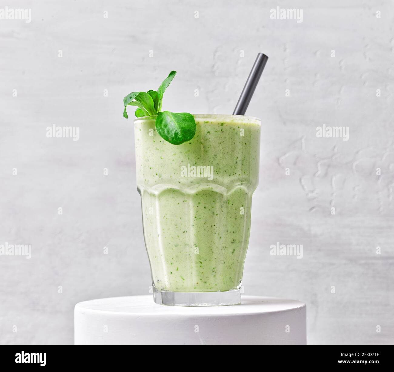 Glas grüner Smoothie auf weißem Ständer Stockfoto