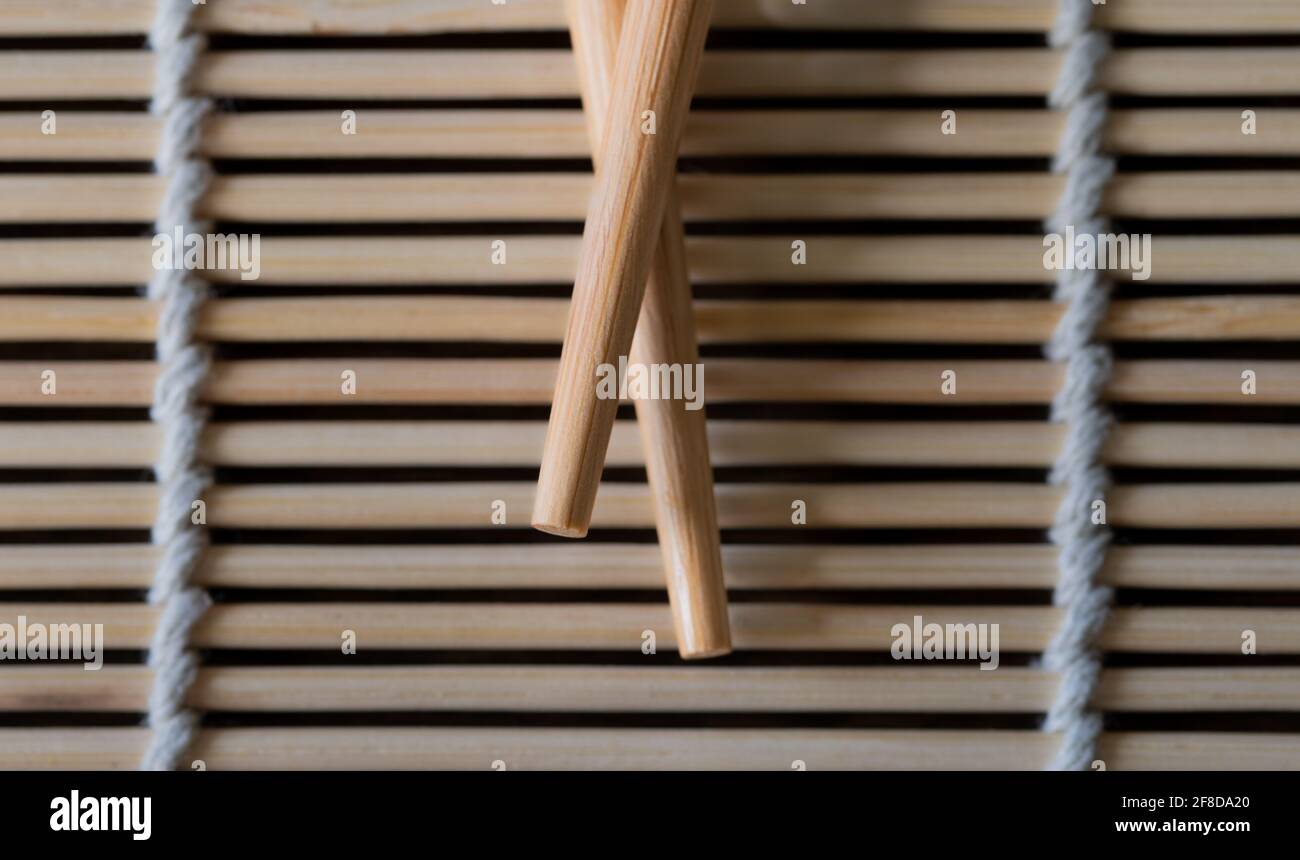 Nahaufnahme von Essstäbchen auf einer Bambusmatte Stockfoto