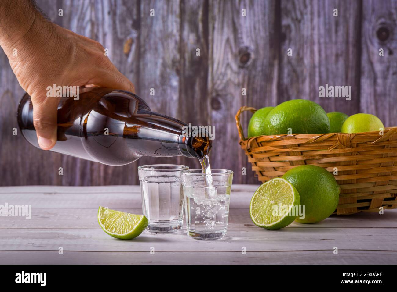 Flasche ausgiessenden Zuckerrohrlikör, ein starkes, typisch brasilianisches alkoholisches Getränk ähnlich Rum, hergestellt in Brasilien aus dem Saft des Zuckerrohrs, in einem s Stockfoto