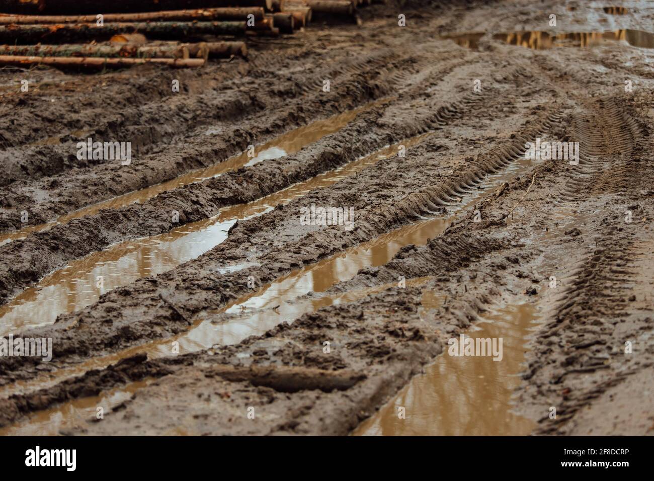 Schlamm auf der schlammigen Straße. Spuren von den Rädern der vorbeifahrenden Autos in den nassen, weichen Boden. Die Straße ist schwierig für den Transport zu passieren. Pfützen Stockfoto