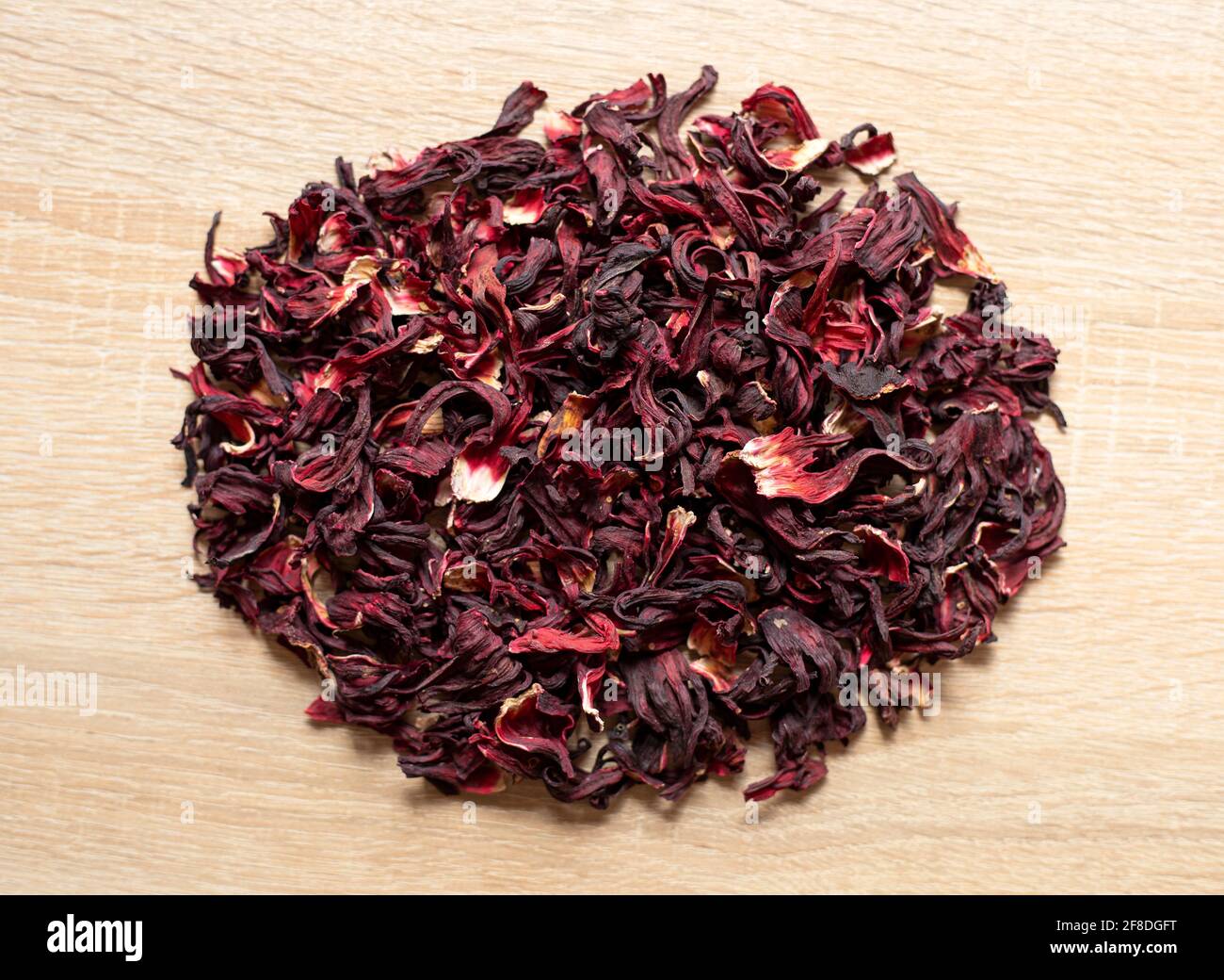 Trockene rote Hibiskusblüten auf einem Holztisch Stockfoto