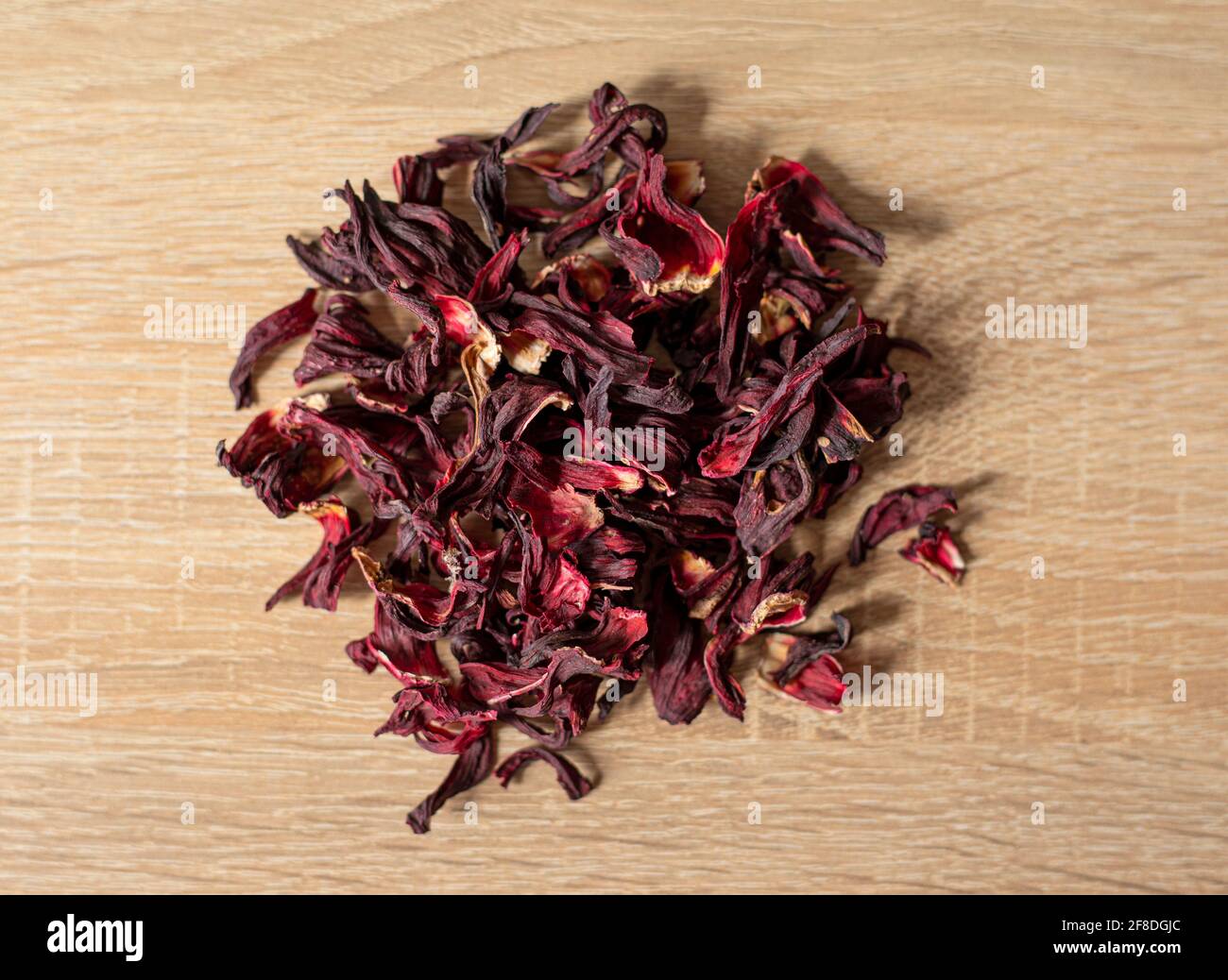Trockene rote Hibiskusblüten auf einem Holztisch Stockfoto