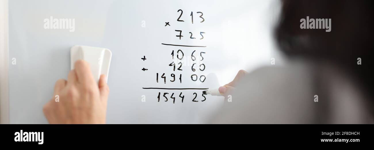Frau auf Whiteboard fügt mathematische Zahlen hinzu Stockfoto