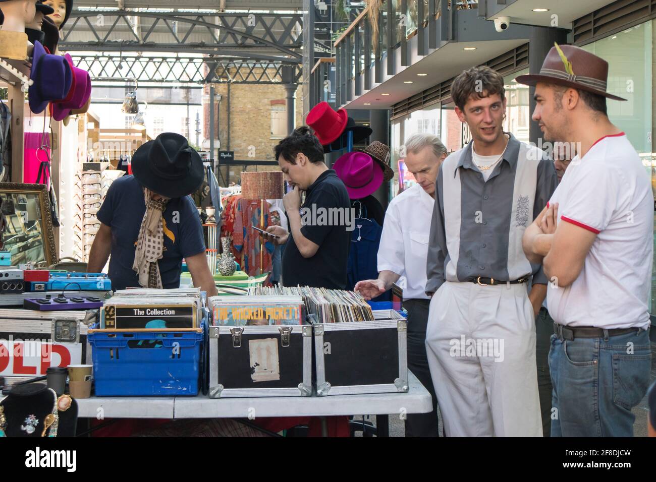London, Großbritannien - 20. September 2020 auf dem Spitalfields Market sehen Käufer alte alte Plattenspieler und Hüte. Zwei Männer im Gespräch Stockfoto