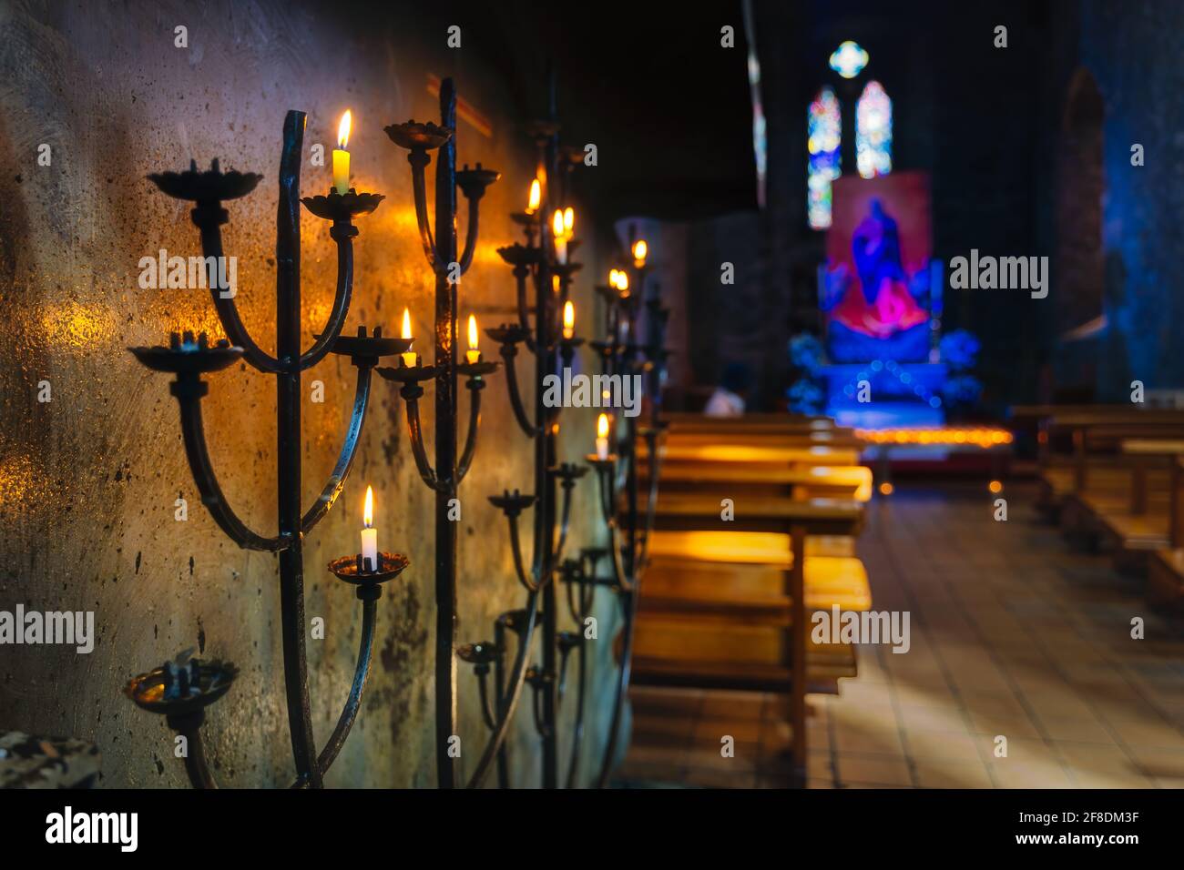 Selektiver Fokus auf Votivkerze auf Kerzenleuchtern mit hellem Glanz, verschwommenem Hintergrund des Innenraums der St Marys Cathedral in Killarney, Kerry, Irland Stockfoto