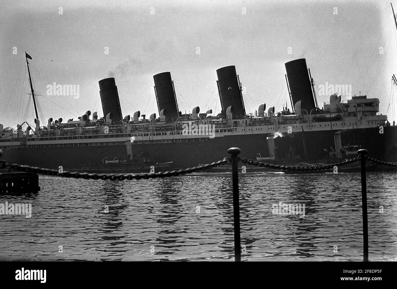 AJAXNETPHOTO. 1931. SOUTHAMPTON, ENGLAND. - CUNARDER REFIT - RMS MAURETANIA WIRD ZUR ÜBERHOLUNG IN DAS SCHWIMMENDE TROCKENDOCK GEZERRT, NACHDEM DER PASSAGIERDAMPFER IN 31 TAGEN VIER MAL DEN NORDATLANTIK ÜBERQUERT HAT. FOTOGRAF:UNBEKANNT © DIGITAL IMAGE COPYRIGHT AJAX VINTAGE PICTURE LIBRARY SOURCE: AJAX VINTAGE PICTURE LIBRARY COLLECTION REF:31 15 Stockfoto