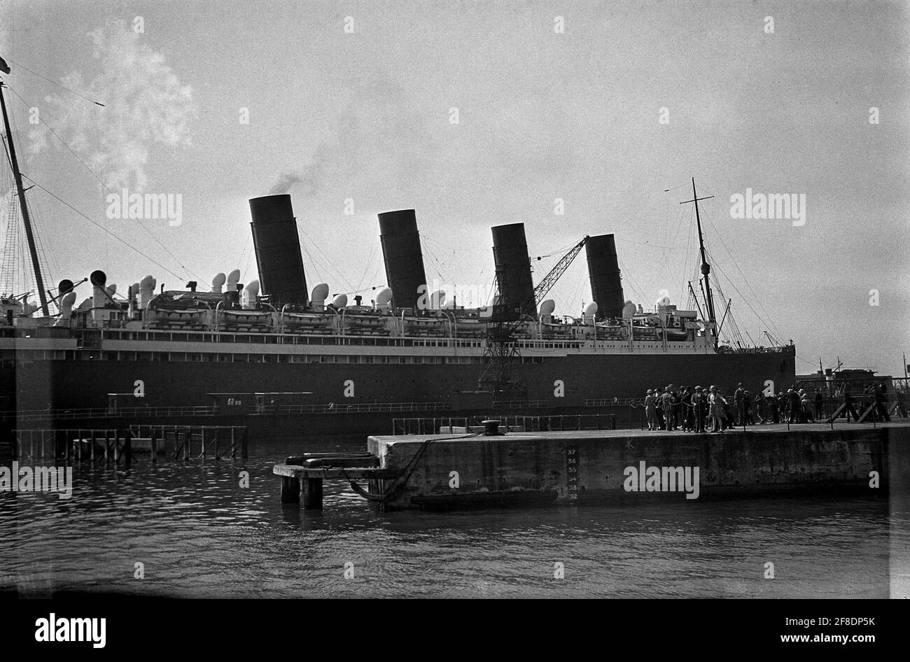 AJAXNETPHOTO. 1931. SOUTHAMPTON, ENGLAND. - CUNARDER REFIT - RMS MAURETANIA WIRD ZUR ÜBERHOLUNG IN DAS SCHWIMMENDE TROCKENDOCK GEZERRT, NACHDEM DER PASSAGIERDAMPFER IN 31 TAGEN VIER MAL DEN NORDATLANTIK ÜBERQUERT HAT. FOTOGRAF:UNBEKANNT © DIGITAL IMAGE COPYRIGHT AJAX VINTAGE PICTURE LIBRARY SOURCE: AJAX VINTAGE PICTURE LIBRARY COLLECTION REF:31 16 Stockfoto