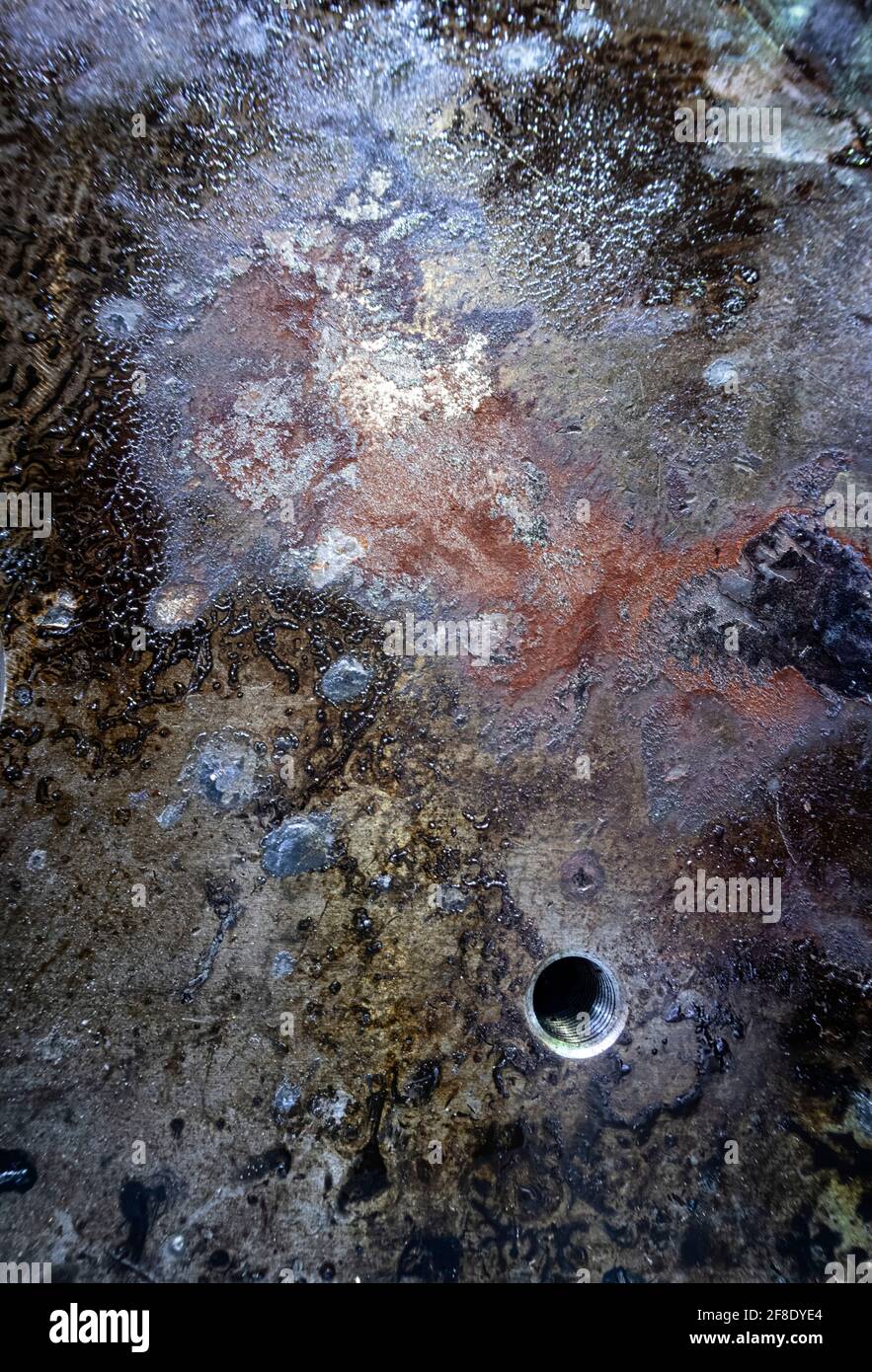 Detail einer verrosteten und ölgebeizten Stahlplatte mit Gewindebohrung, verrostete Metallstruktur, Ähnlichkeit mit einer Galaxie von Sternen Stockfoto