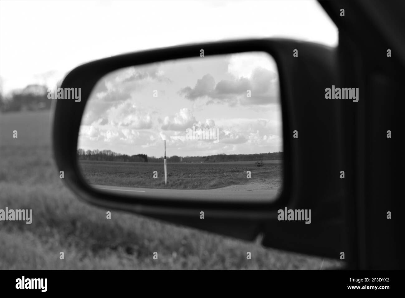 Die Landschaft spiegelt sich im Außenspiegel eines wider Auto als Monochron-Bild Stockfoto