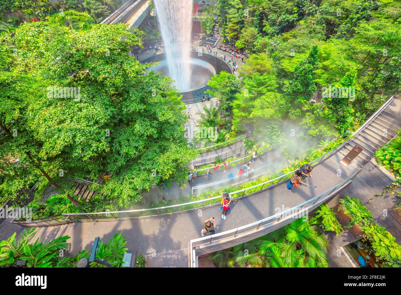Singapur - 8. Aug 2019: Luftaufnahme der Details von Rain Vortex, dem größten Indoor-Wasserfall der Welt und dem terrassenförmig angelegten Hedge-Labyrinth-Garten im Jewel Airport Stockfoto