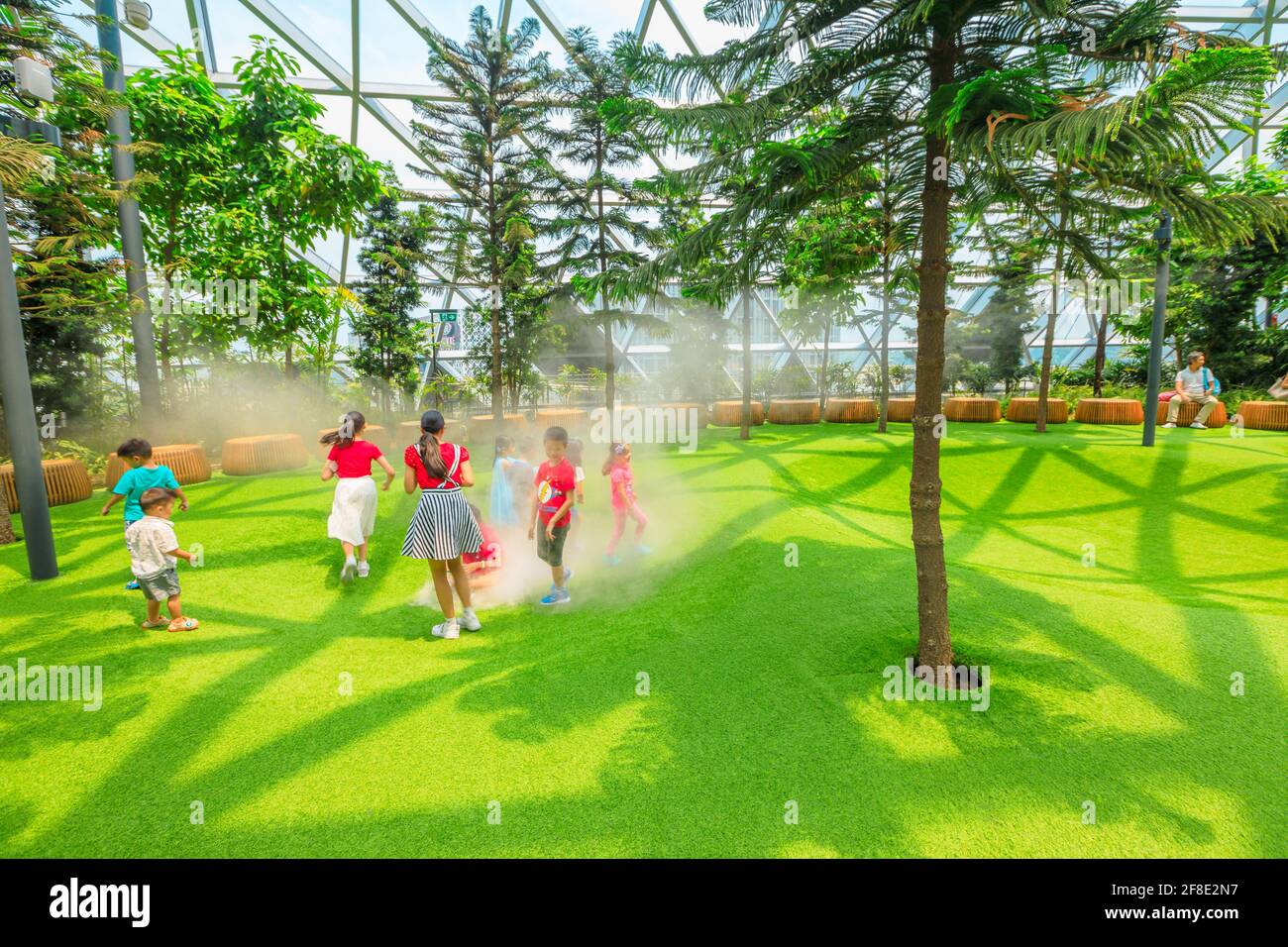 Singapur - Aug 8, 2019: Lustige Kinder bei Foggy Bowls, einem einfachen Spielplatz, sind schalenförmige Plattformen mit künstlichem Rasen, die Nebel freisetzen Stockfoto