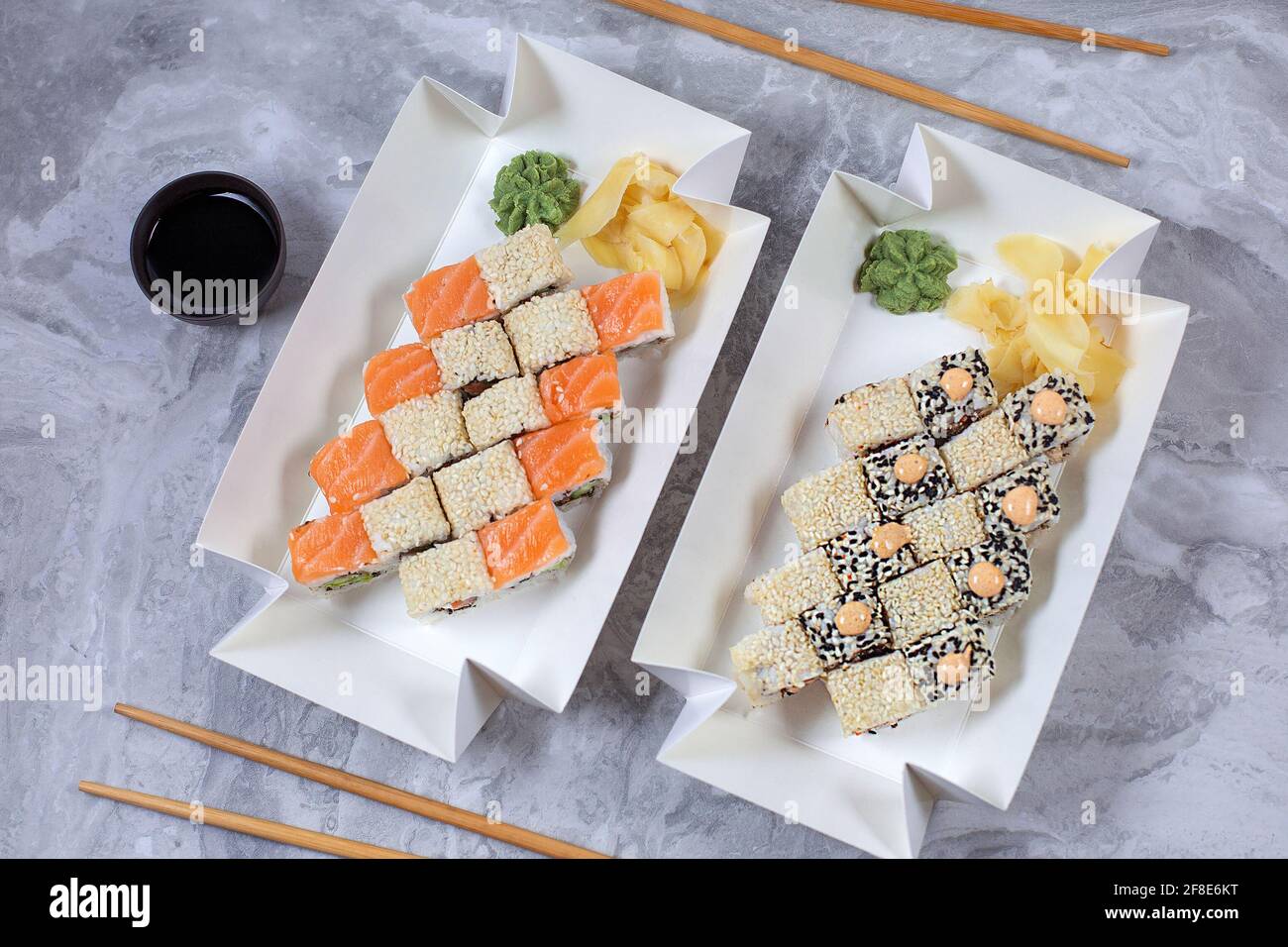 Zwei Sushi-Sets wurden in einem Öko-Behälter aus Papier geliefert. Mittagspause am Arbeitsplatz. Sushi to Go-Konzept. Draufsicht Stockfoto