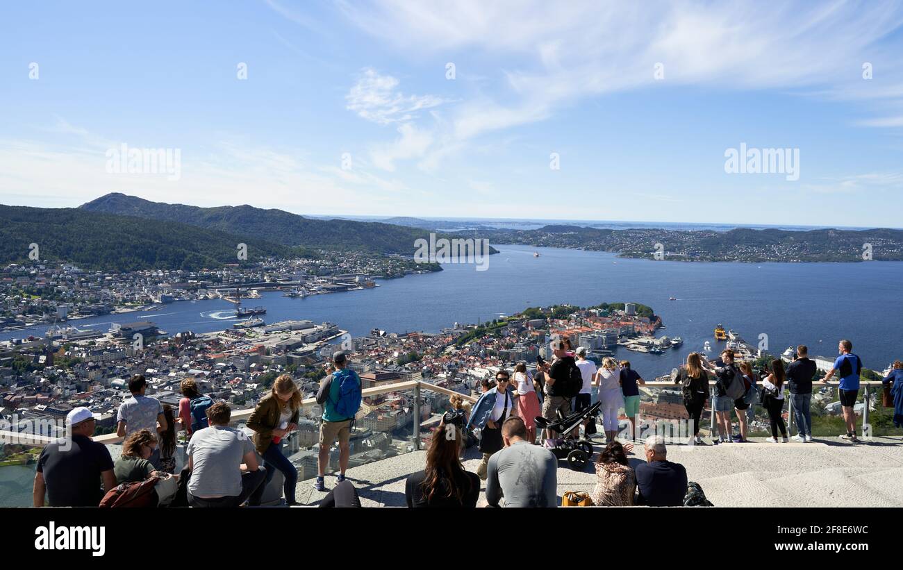 BERGEN, NORWEGEN - 23. Jul 2020: Viele Touristen bewundern den Blick auf den Hafen von Bergen von der Spitze eines nahegelegenen Hügels, dem Floyen, während eines sonnigen Sommers Stockfoto