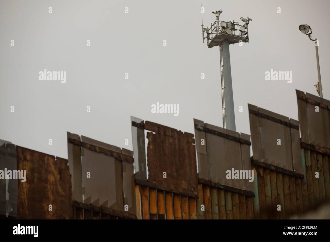 Die amerikanische Grenzüberwachung erhebt sich über der Grenzmauer der USA und Mexikos in Tijuana, Mexiko. Stockfoto