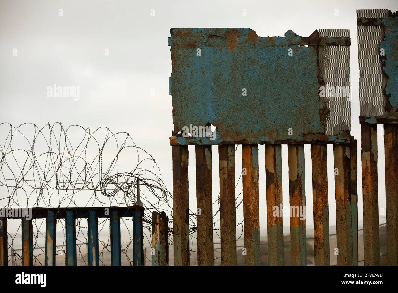 Ein launisch bedecktes Himmelsgewölbe bildet den Hintergrund für die Grenzmauer der USA und Mexikos in Tijuana, Mexiko. Stockfoto