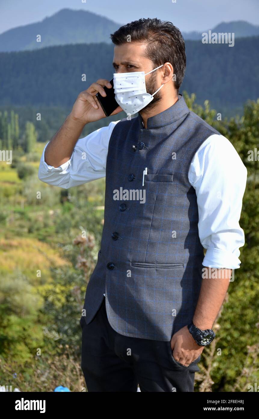 Asian man Tragen Maske ist am Telefon an einem schönen Ort nach Coronavirus Lockdown sprechen. Stockfoto