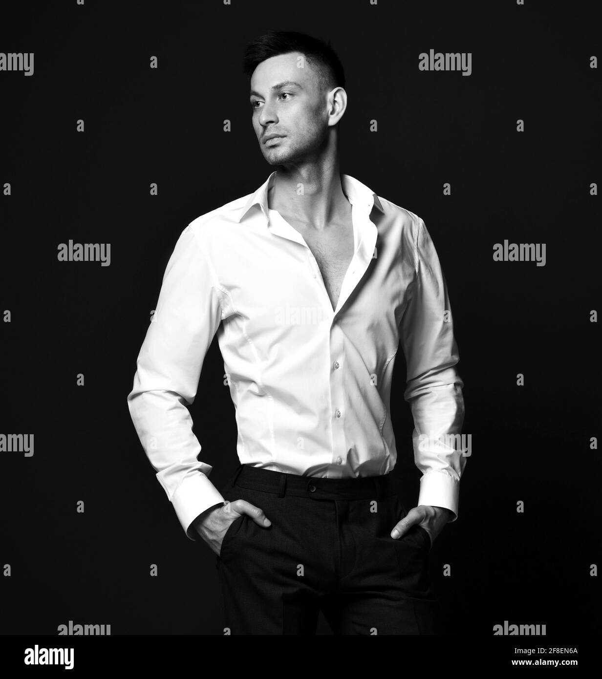 Schwarz-Weiß-Porträt des jungen selbstbewussten Geschäftsmann in offiziellen Anzughose und Hemd stehen zur Seite Stockfoto