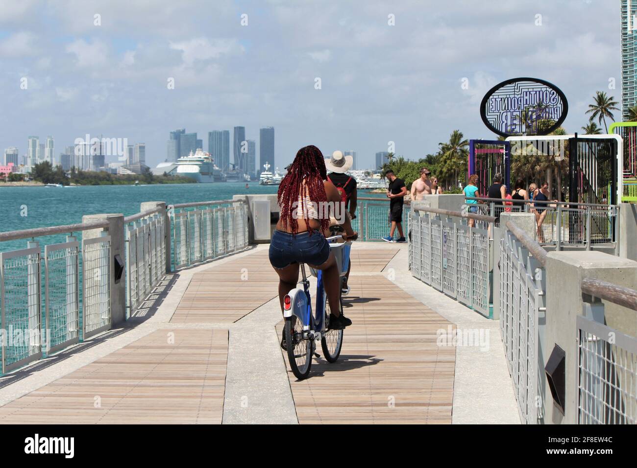 Frau und Mann reiten auf dem South Pointe Pier in Miami Beach, South Beach in Florida während der Frühlingsferien Fahrrad. Stockfoto