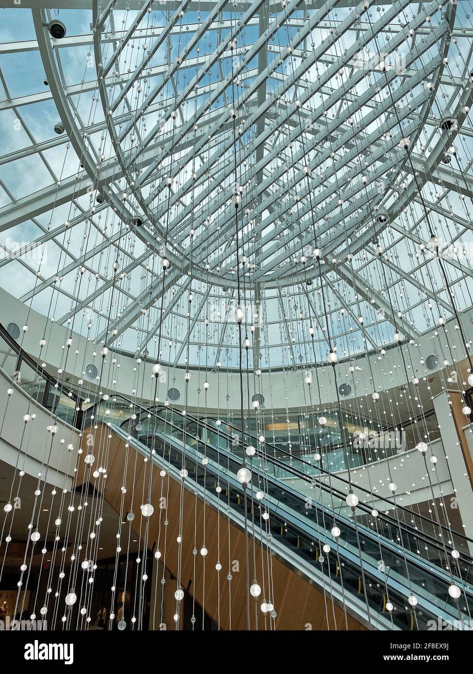 Baumelnde Lichter in der Aventra Mall in Südflorida. Innendekoration für die Öffentlichkeit. Nette Hängelampen an der Rolltreppe. Stockfoto