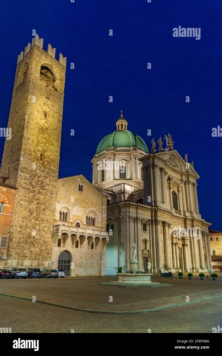 Nachtansicht des Palazzo del Broletto hinter der Kathedrale Santa Maria Assunta in Brescia, Italien Stockfoto