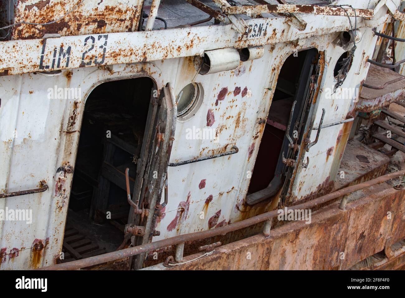 Mangystau, Kasachstan - 19. Mai 2012: Altes verrosttes Schiff am Kaspischen Meer, Bucht von Bautino, Schiffsreparaturwerft. Nahaufnahme von Türen und Bullaugen. Stockfoto