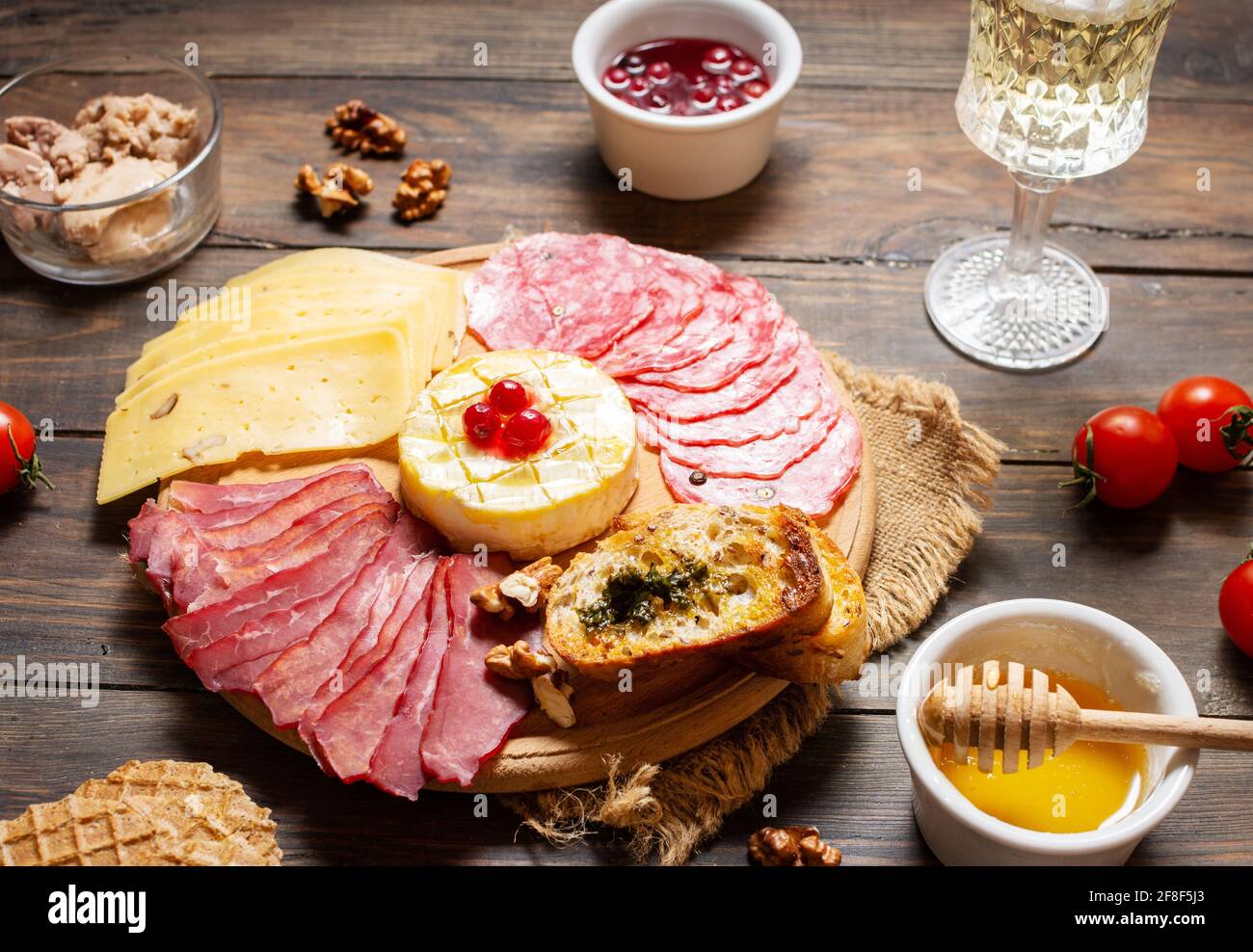 Antipasto Platte kaltes Fleisch mit Brot, Salami, Scheiben Schinken und Käse auf einem hölzernen Hintergrund Stockfoto