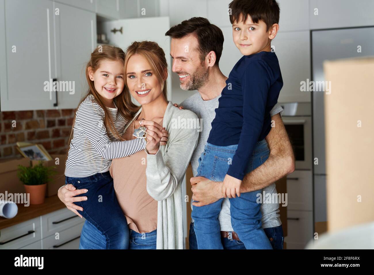Porträt einer lächelnden Familie mit Kindern in einer neuen Wohnung Stockfoto