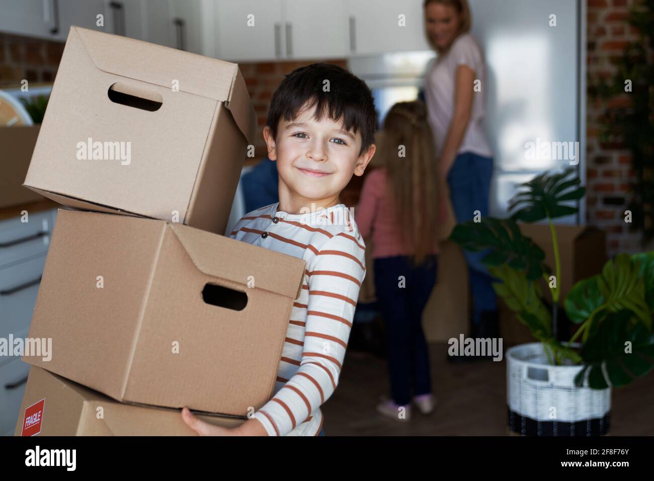 Porträt eines lächelnden Jungen, der einen Karton in der Hand hält Stockfoto