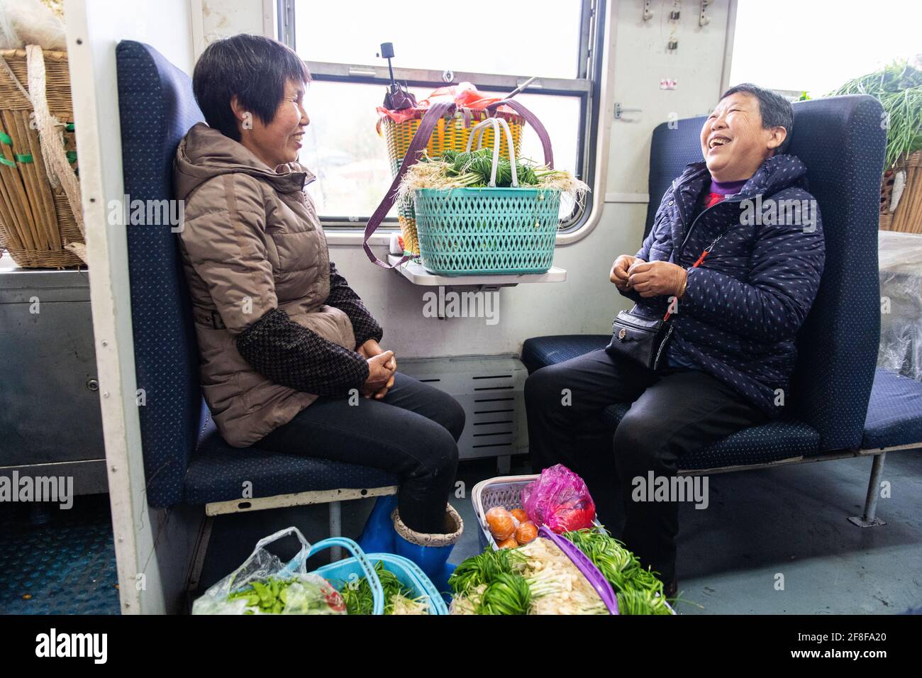 (210414) -- CHANGSHA, 14. April 2021 (Xinhua) -- Passagiere unterhalten sich im Zug 7266 in der zentralchinesischen Provinz Hunan, 11. April 2021. Die 7265/7266/7267-Züge wurden 1995 in Betrieb genommen und erstrecken sich über mehr als 300 Kilometer vom Bahnhof Huaihua zum Bahnhof Lixian. Die Züge fahren in 9 Stunden und 16 Minuten an 37 Haltestellen vorbei. Die Ticketpreise reichen von 1 Yuan bis 23.5 Yuan (etwa 0.15-3.59 US-Dollar), die seit 26 Jahren nicht mehr angehoben wurden. Die Züge fahren durch die Wuling Mountains. Dank ihnen können die Dorfbewohner nicht nur Obst, Gemüse und andere lokale Produkte mitnehmen Stockfoto