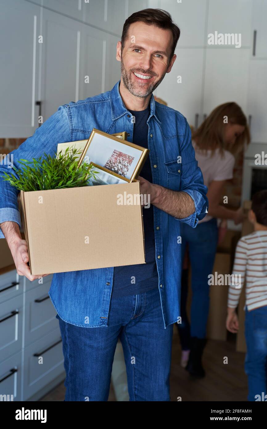 Porträt eines lächelnden Mannes, der während der Bewegung einen Karton in der Hand hält Stockfoto