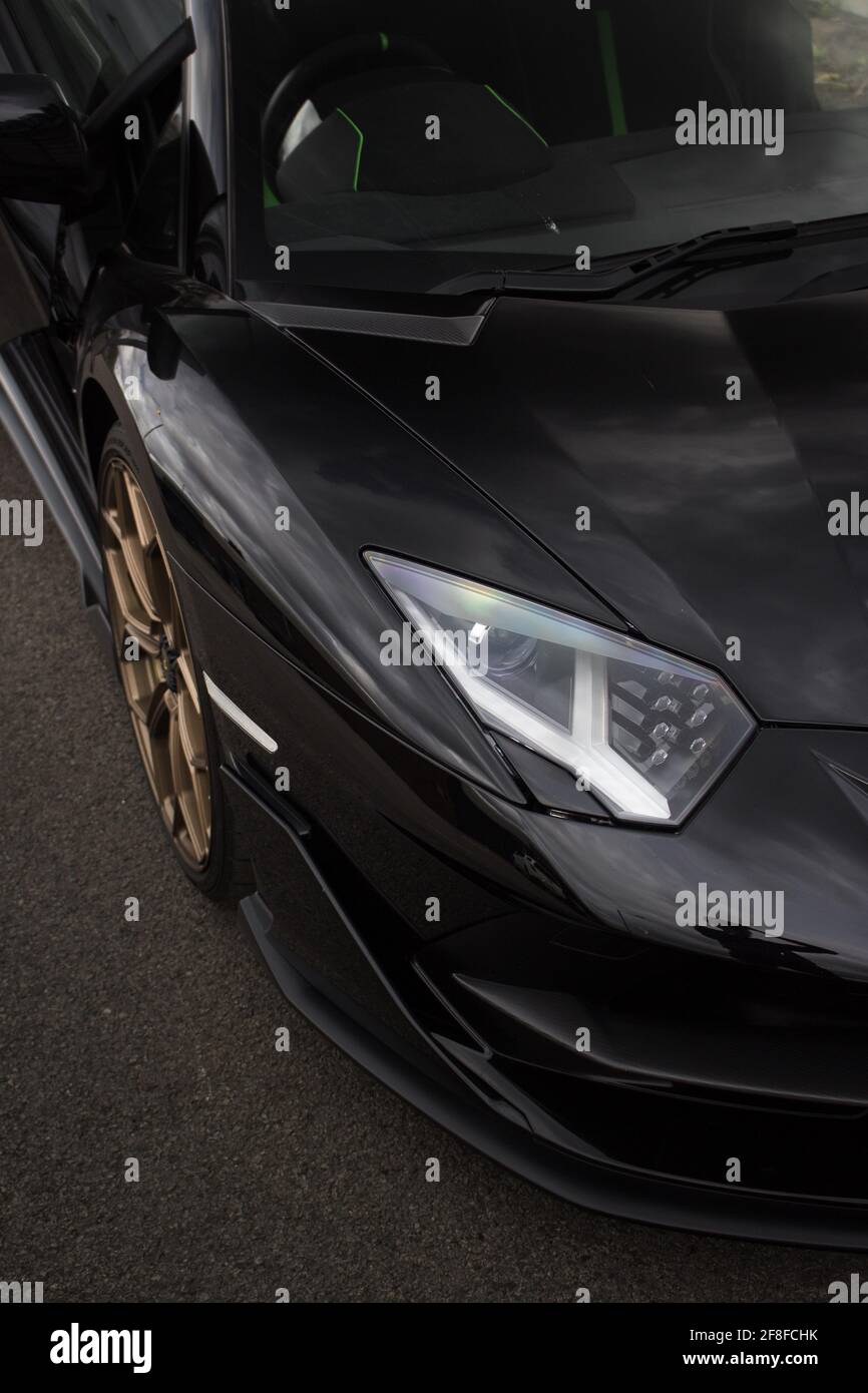Eine schwarze 2020 Lamborghini Aventador SVJ Frontblende mit Goldene Leichtmetallräder und LED-Scheinwerfer mit Aerodynamik vorne Stockfoto