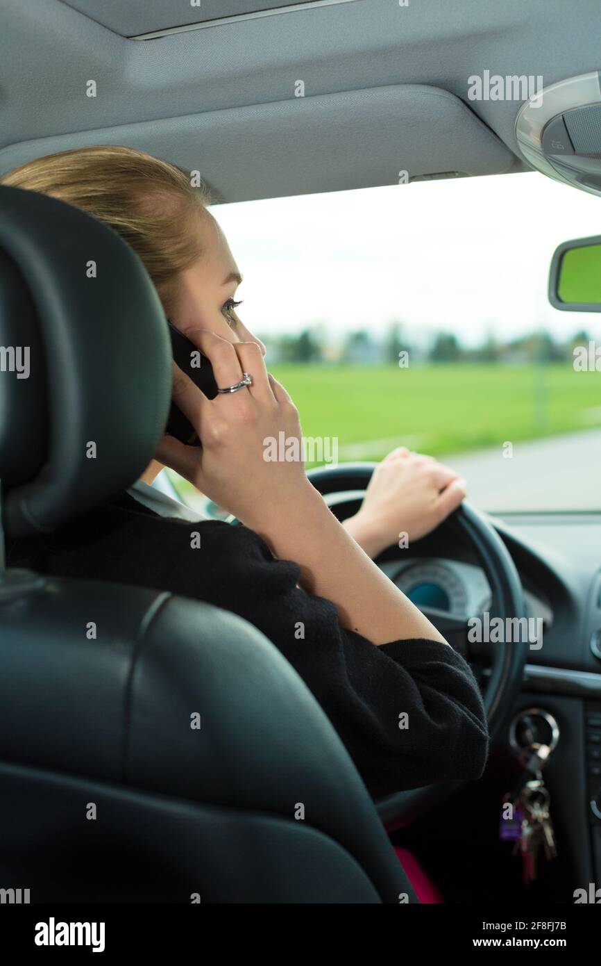 Junge Frau mit Telefon Telefon Gespräch während der Fahrt Auto Stockfoto