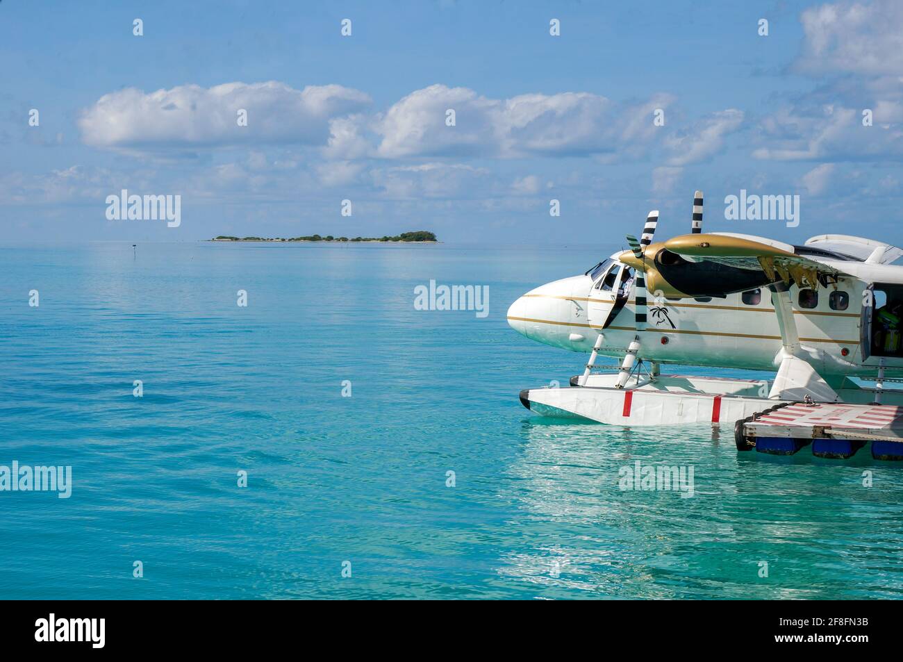 Weißes Wasserflugzeug auf der türkisfarbenen maledivischen Lagune. Luxuriöses Reisekonzept Stockfoto