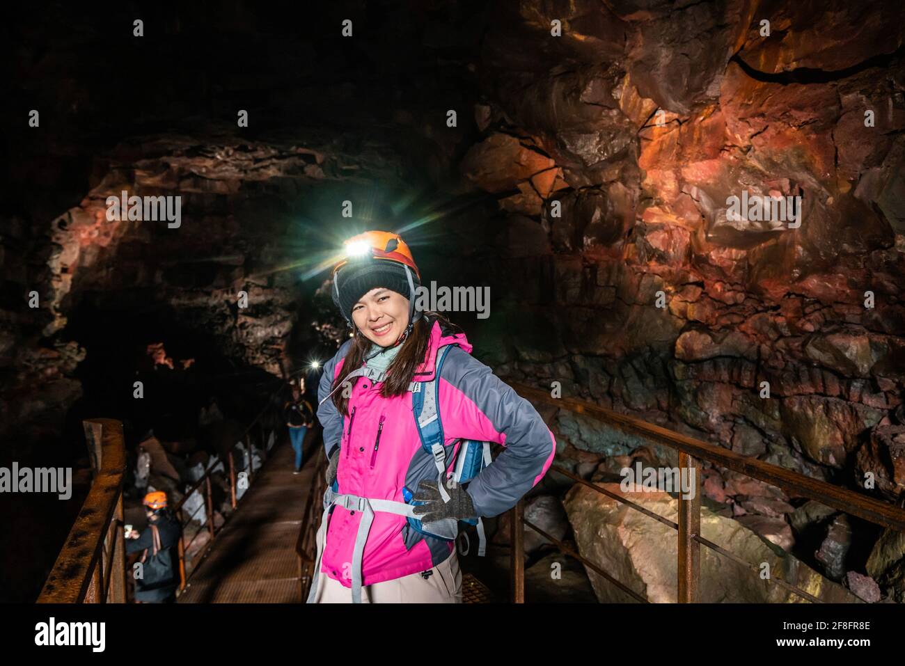 Frau Reisende erkunden Lava-Tunnel in Island. Raufarholshellir ist eine schöne versteckte Welt der Höhle. Es ist eine der längsten und bekanntesten Lava Stockfoto