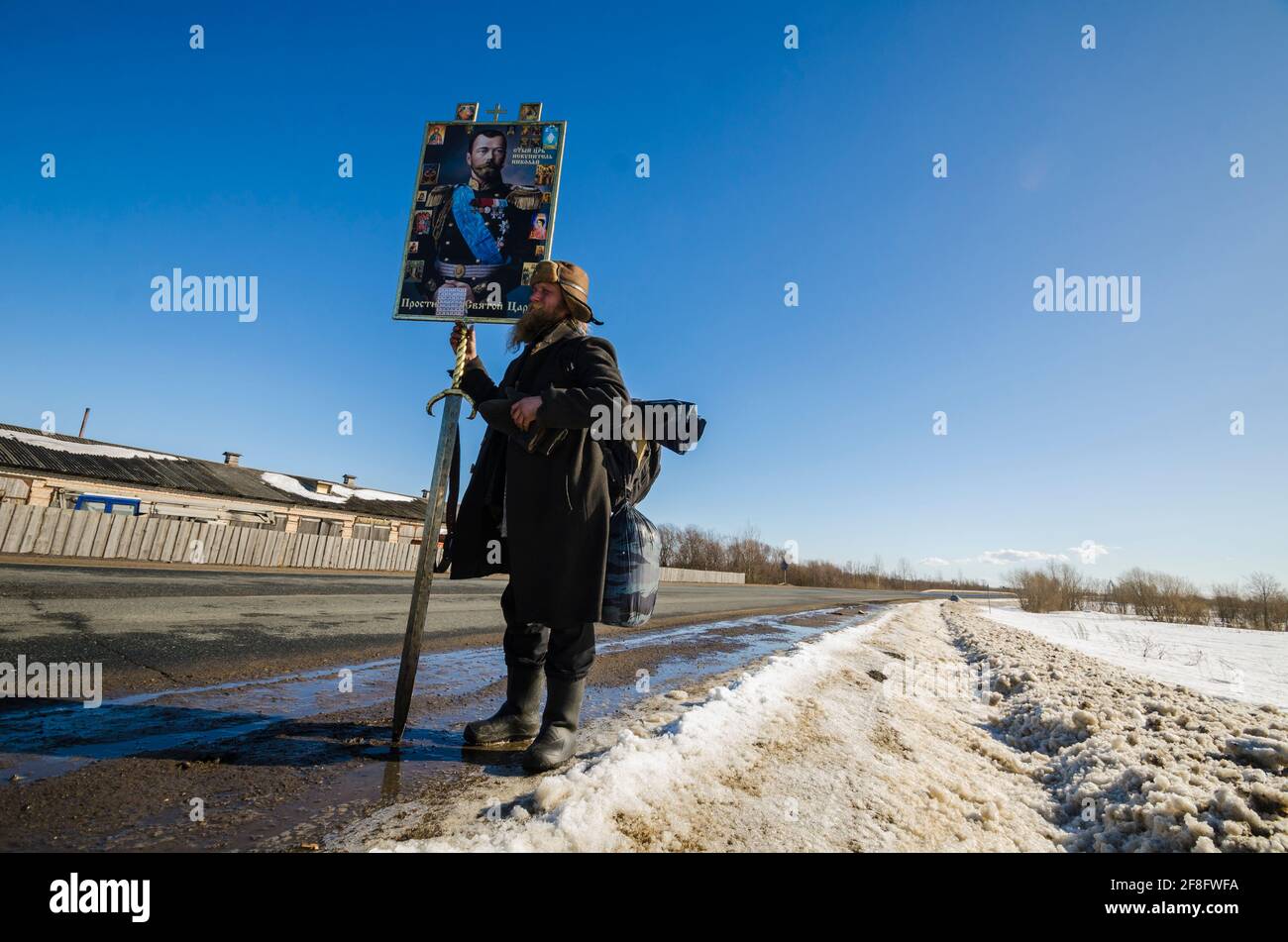 März 2021 - Kholmogory. Russische religiöse Prozession. Wanderer mit einem Schwert und einer Ikone des Zaren Nikolaus II. Russland, Region Archangelsk Stockfoto