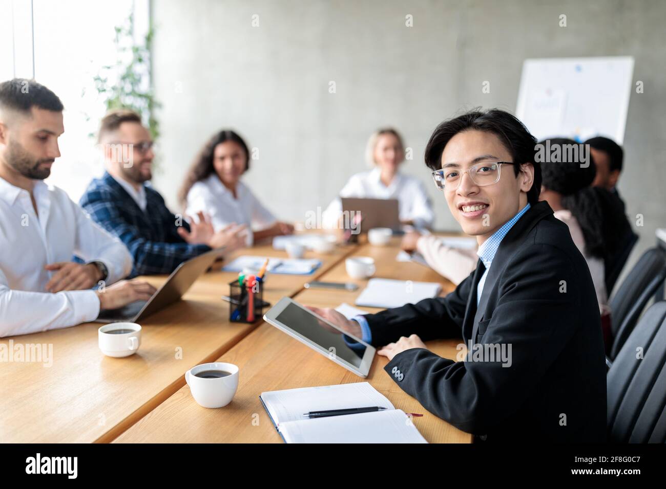 Asiatischer Geschäftsmann, Der Ein Digitales Tablet Nutzt, Nimmt An Einem Corporate Meeting Im Büro Teil Stockfoto