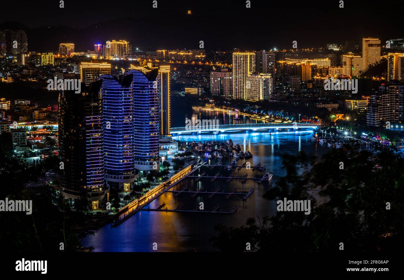 Malerisches Panorama der Stadt Sanya bei Nacht mit Sanya beleuchtet Flussbrücke und moderne Gebäude in Sanya Hainan Island China Stockfoto
