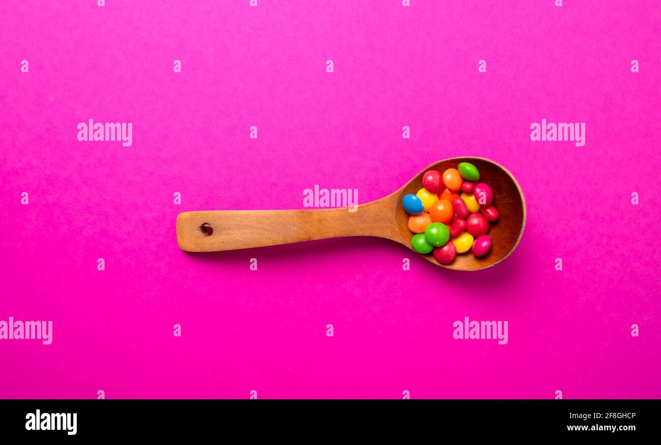 Mehrfarbiges Bonbon-Set mit einem Holzlöffel Stockfoto