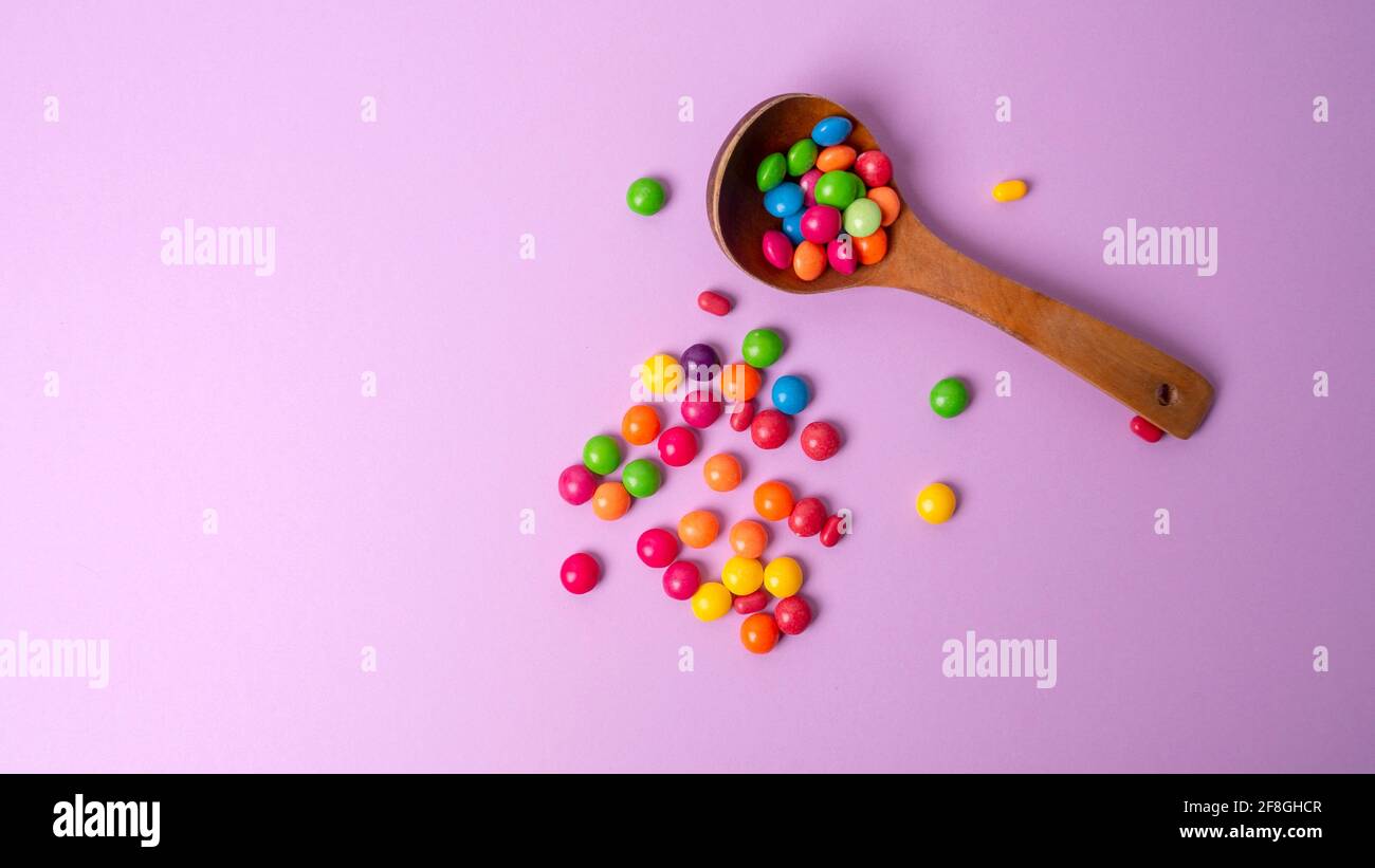 Mehrfarbiges Bonbon-Set mit einem Holzlöffel Stockfoto