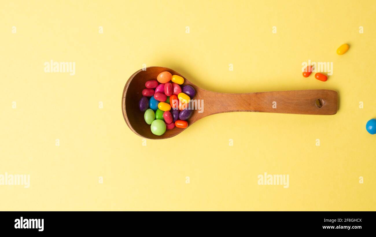 Mehrfarbiges Bonbon-Set mit einem Holzlöffel Stockfoto
