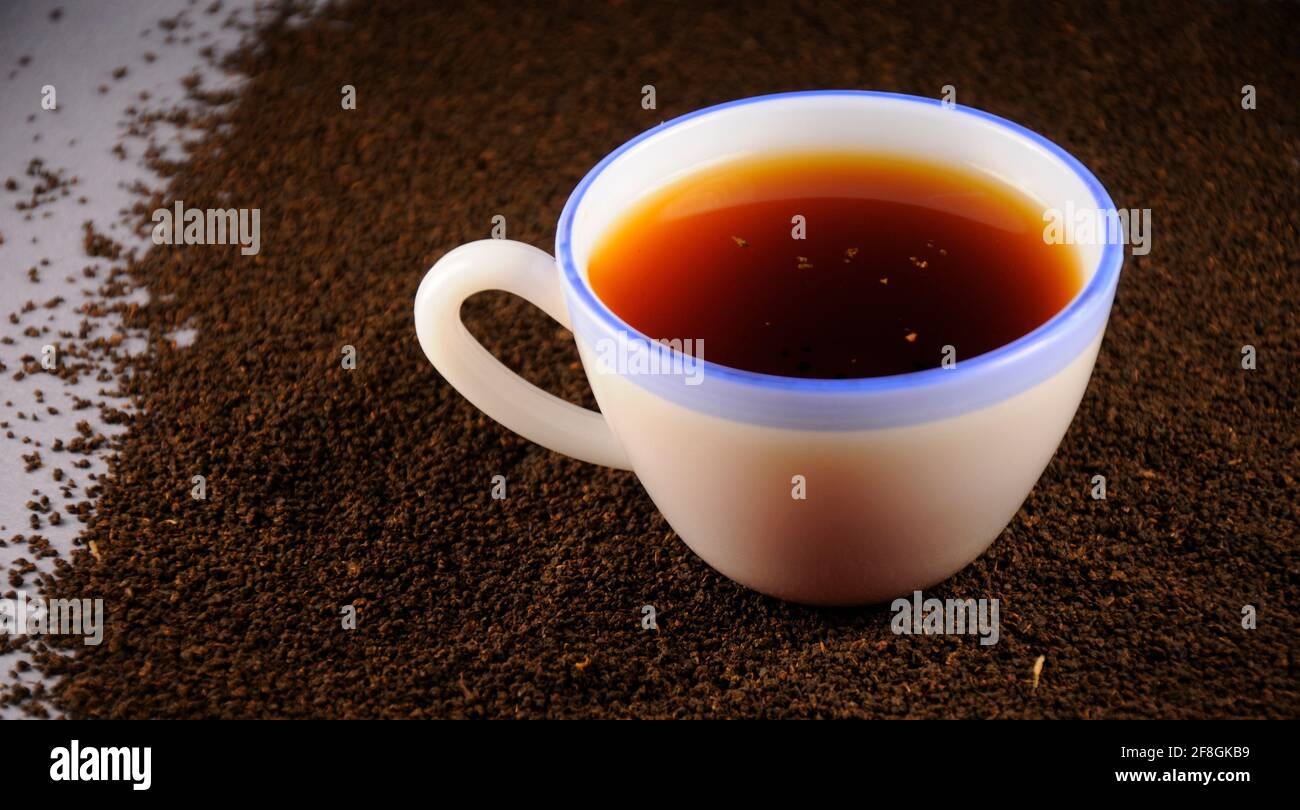 Tasse Tee mit schwarzen Teeblättern Stockfoto