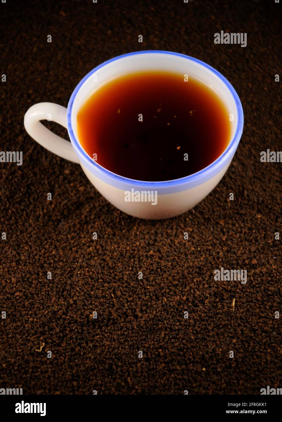 Tasse Tee mit schwarzen Teeblättern Stockfoto